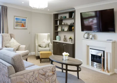 Cosy lounge at Henley House Care Home, Ipswich – softly lit seating area with armchairs and homely décor