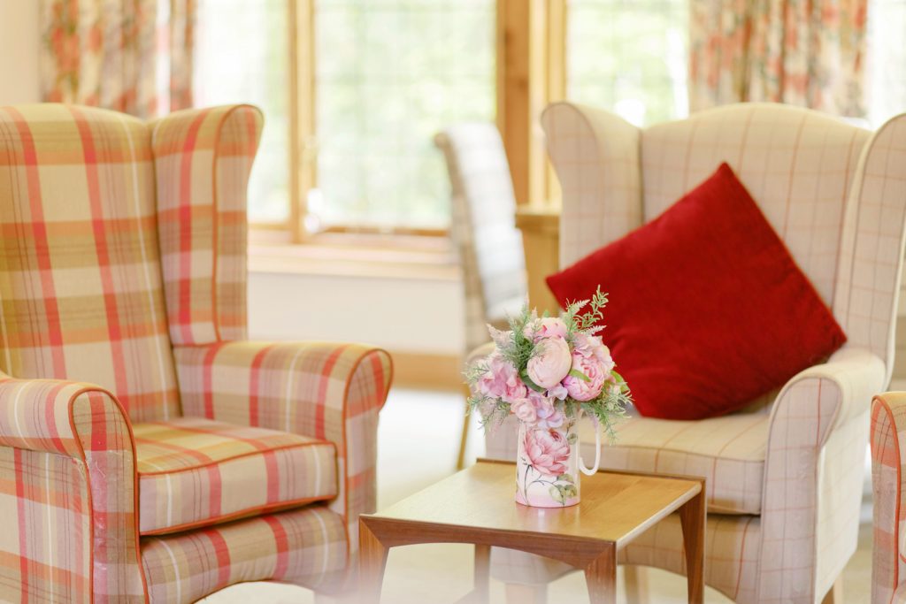 Cozy Broadacres lounge with plaid armchairs and floral table decor