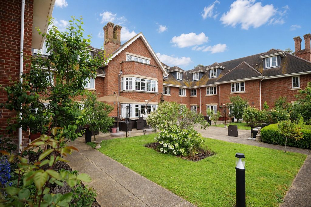 Brick manor courtyard with landscaped garden and patio seating