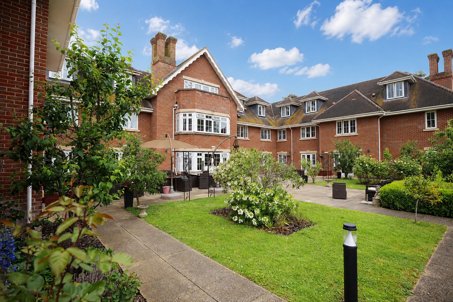 Brick manor courtyard with landscaped garden and patio seating