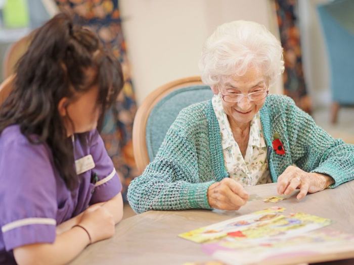 A Greensleeves Care colleague doing a jigsaw with a resident