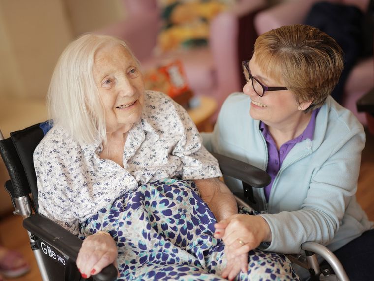 A nurse checking in with a resident in their room
