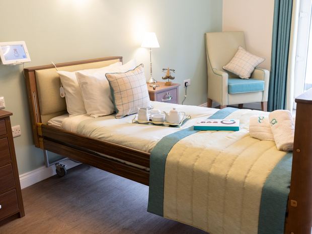 A bright, furnished en-suite bedroom in a Greensleeves care home